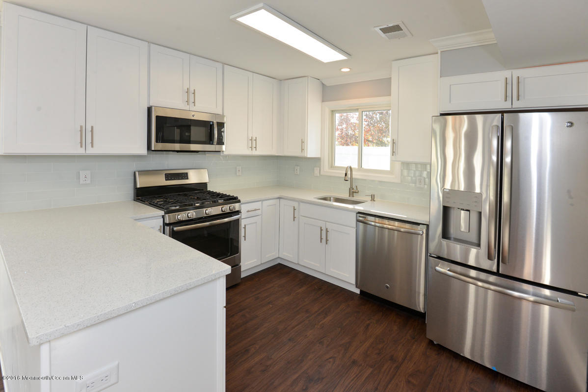 93 Friendship Road Howell, NJ 07731 - Photo 5 of 51 a kitchen with cabinets stainless steel appliances and wooden floor