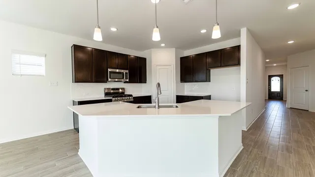 a view of kitchen with kitchen island a sink and a microwave