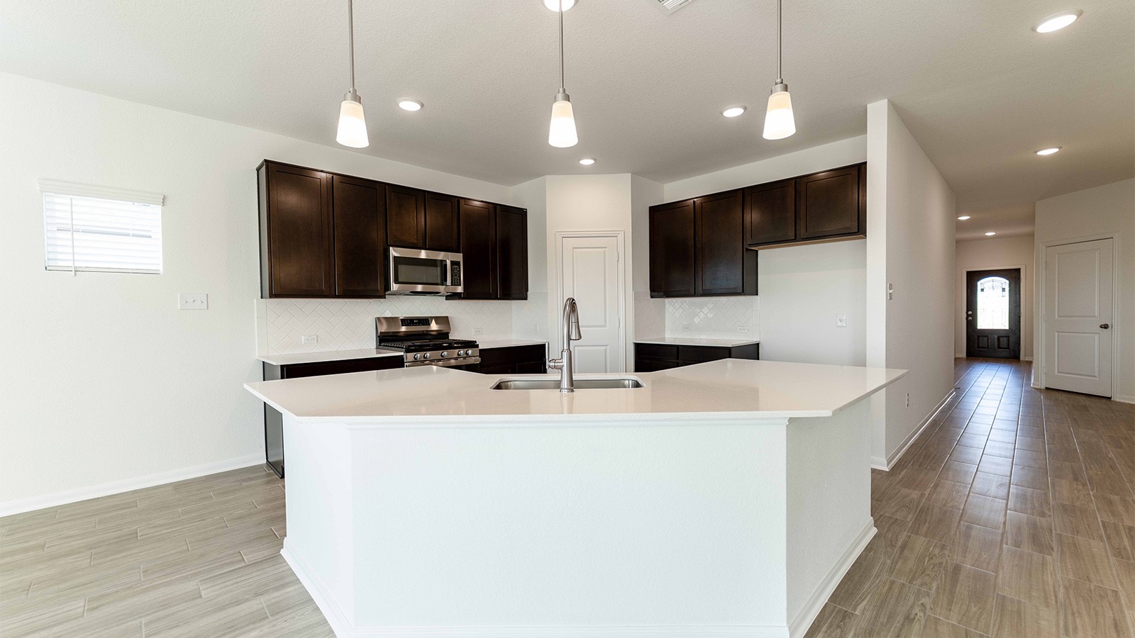 13613 Endless Narrow Lane Elgin, TX 78621 - Photo 5 of 16 a view of a kitchen with kitchen island a sink and a microwave