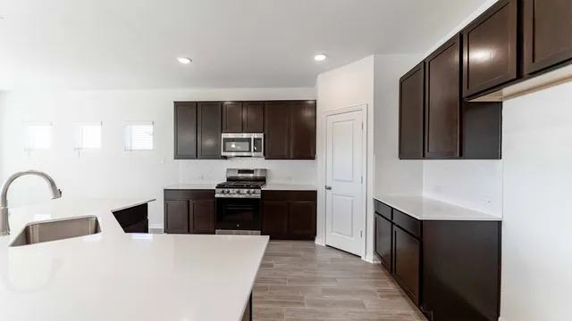 a kitchen with stainless steel appliances kitchen island a refrigerator sink and stove
