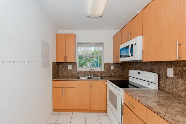 a kitchen with granite countertop cabinets stainless steel appliances and a sink
