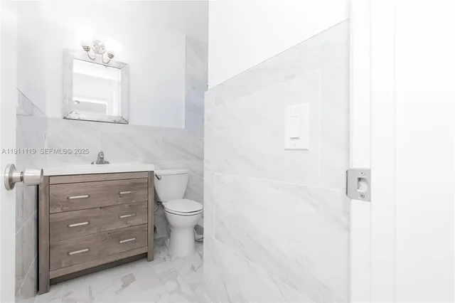 a bathroom with a toilet sink vanity and mirror