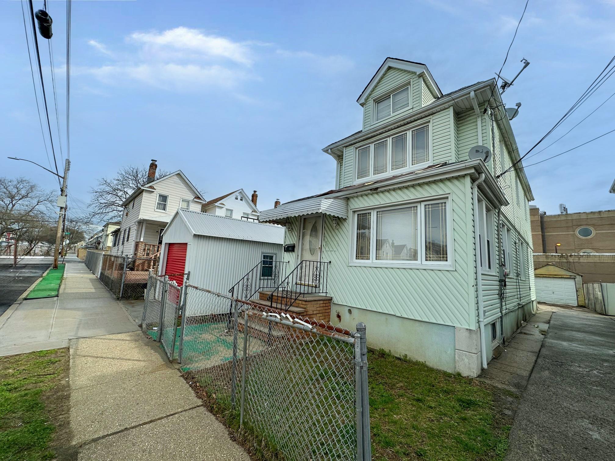 Traditional style home featuring an outdoor structure, fence, and a gate