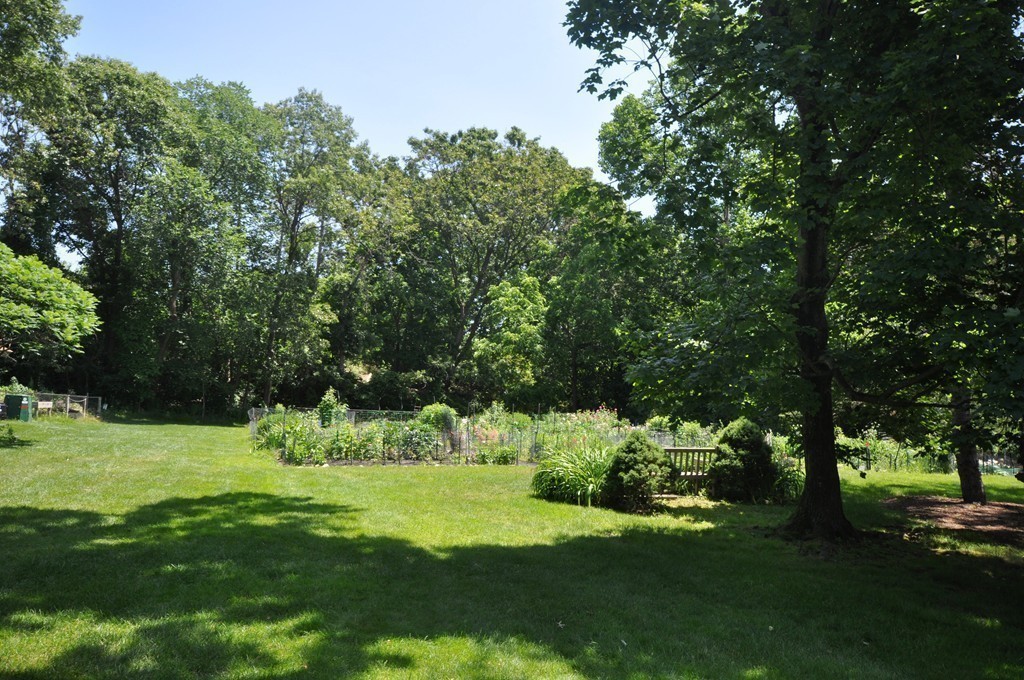 29 Concord Greene, Unit 4 Concord, MA 01742 - Photo 20 of 23 a garden with trees in front of it