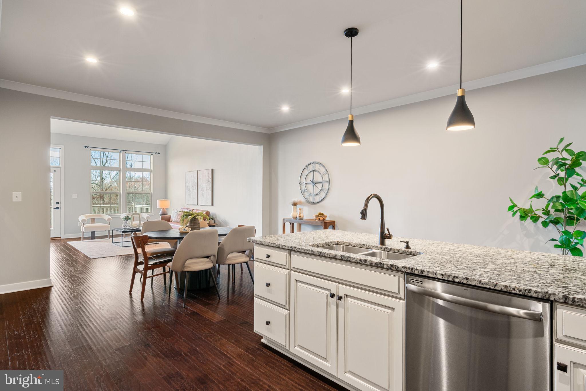 18180 Red Mulberry Road Dumfries, VA 22026 - Photo 14 of 87 a open kitchen with stainless steel appliances granite countertop a stove top oven a sink dishwasher a dining table and chairs with wooden floor