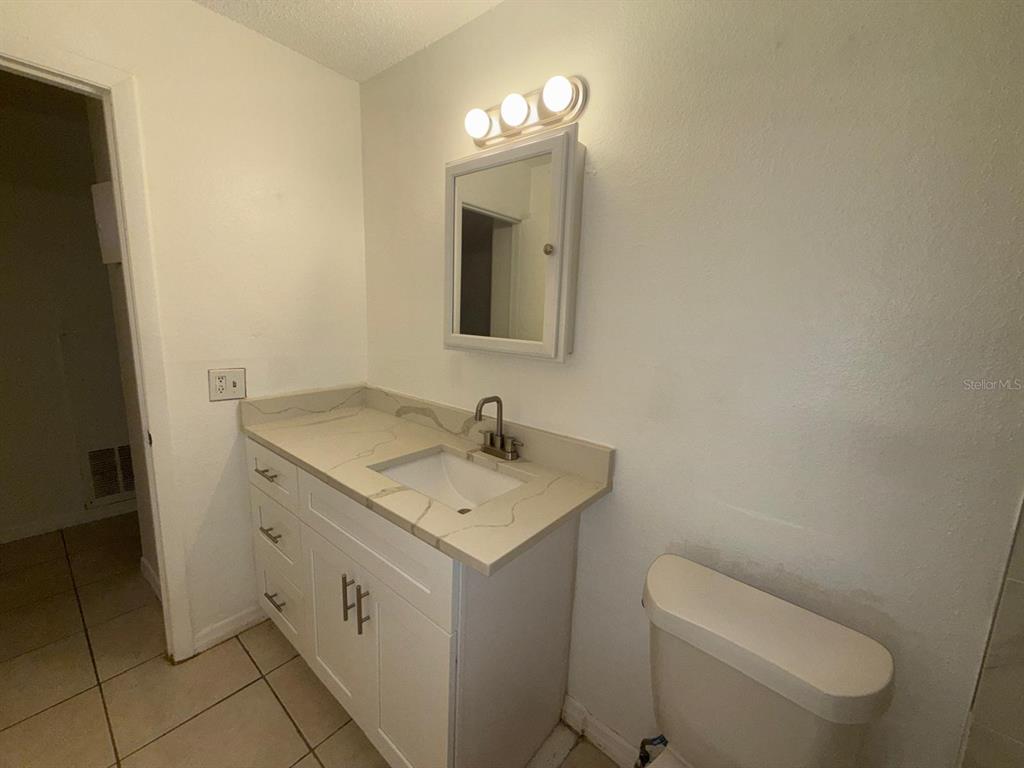 719 Michigan Court, Unit 3 St. Cloud, FL 34769 - Photo 11 of 17 a bathroom with a toilet sink and mirror