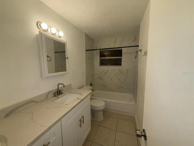 a bathroom with a sink a toilet a shower and a mirror