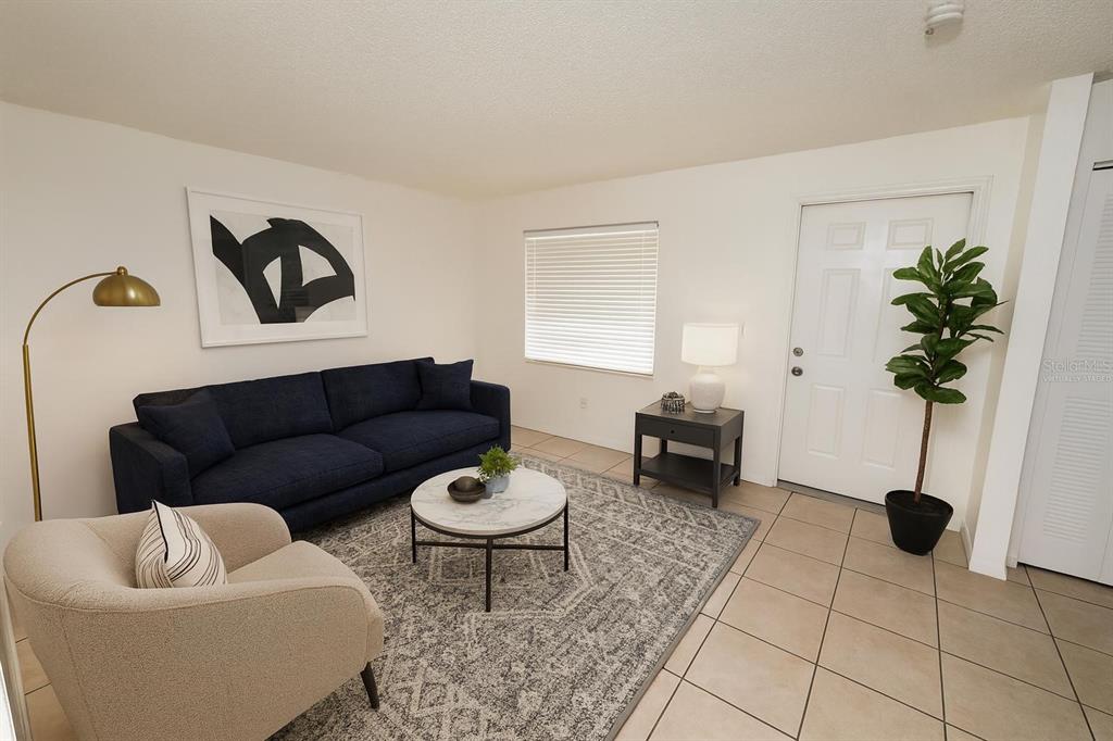 719 Michigan Court, Unit 3 St. Cloud, FL 34769 - Photo 5 of 17 a living room with furniture and a potted plant