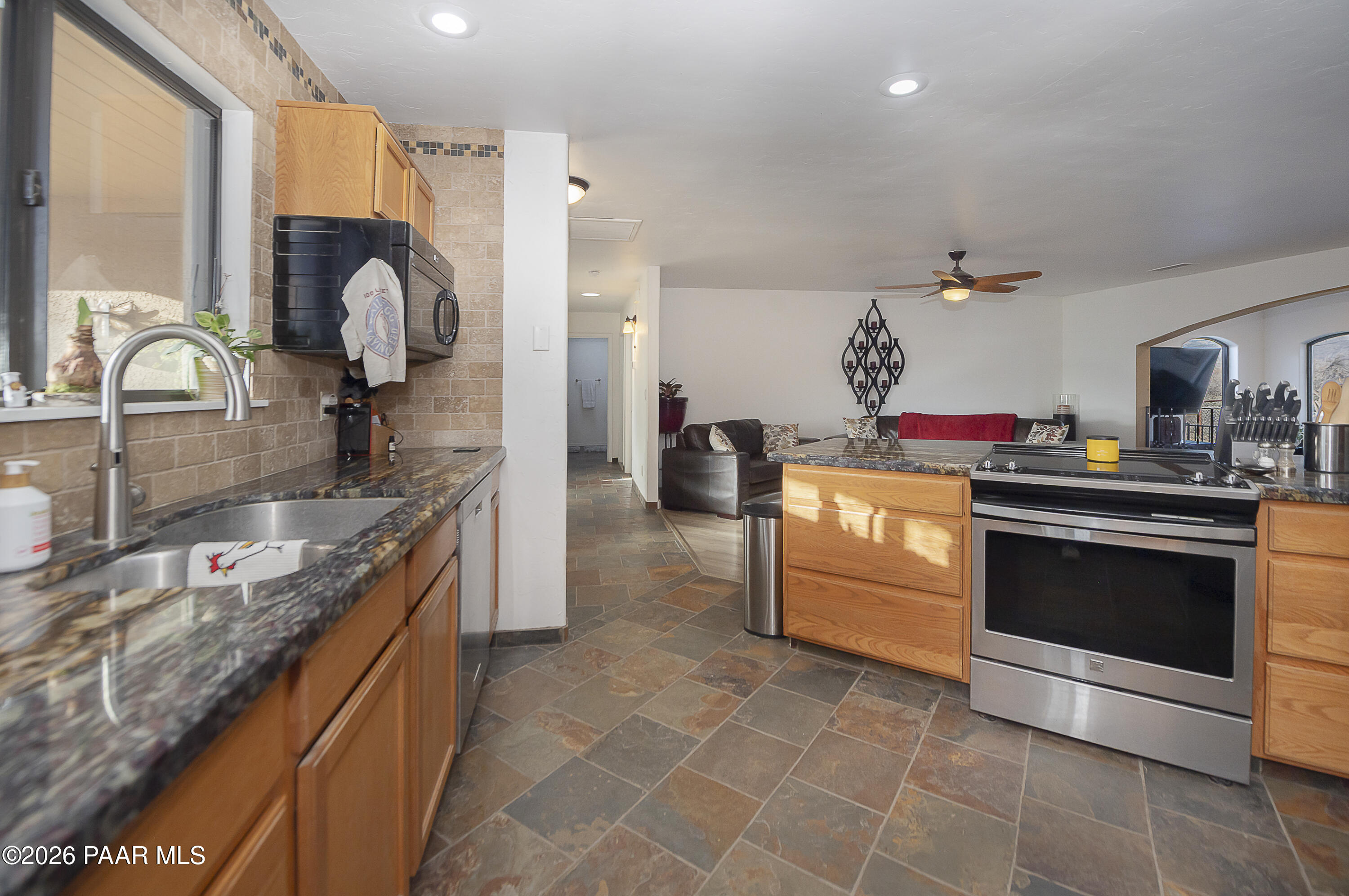 6565 Musgrove Road Skull Valley, AZ 86338 - Photo 16 of 65 a kitchen with stainless steel appliances granite countertop a stove a sink and a refrigerator