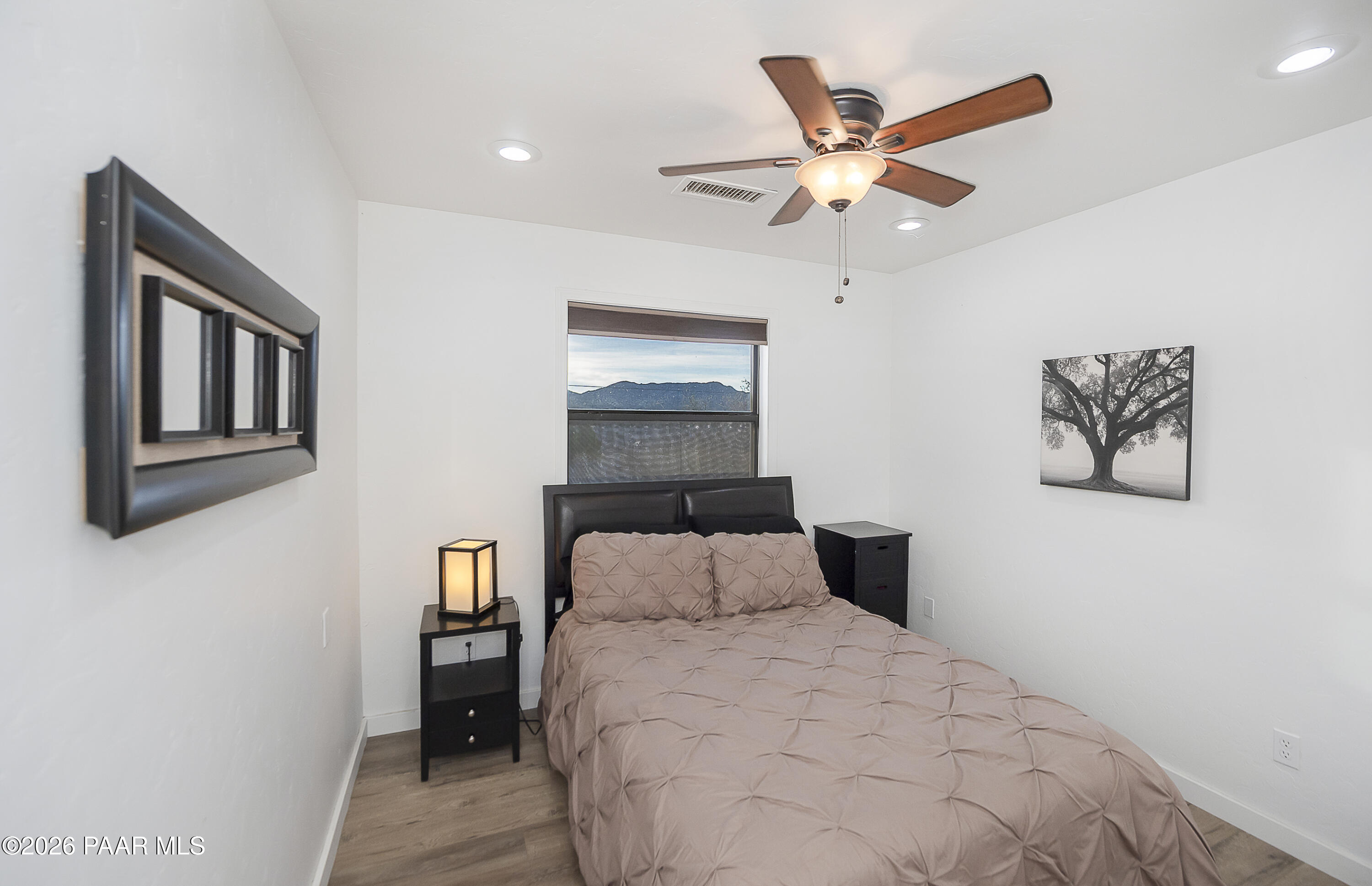 6565 Musgrove Road Skull Valley, AZ 86338 - Photo 26 of 65 a bedroom with a large bed and a ceiling fan