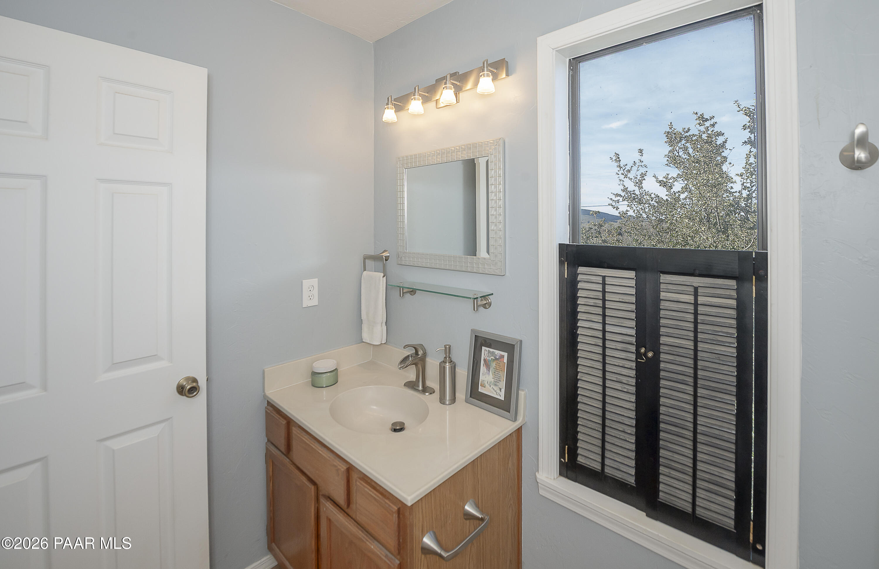 6565 Musgrove Road Skull Valley, AZ 86338 - Photo 32 of 65 a bathroom with a sink vanity and a mirror