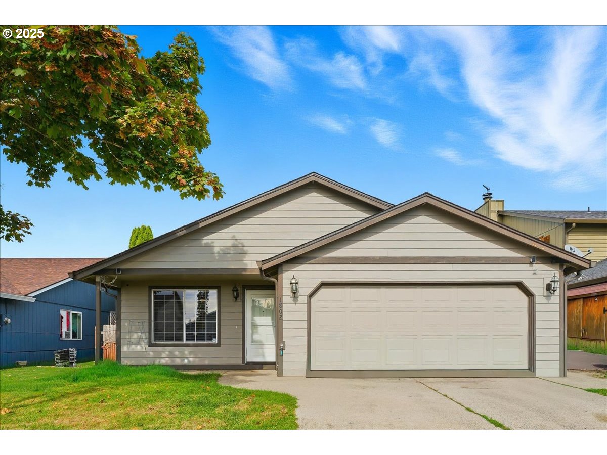 a view of a white house with large windows and a yard