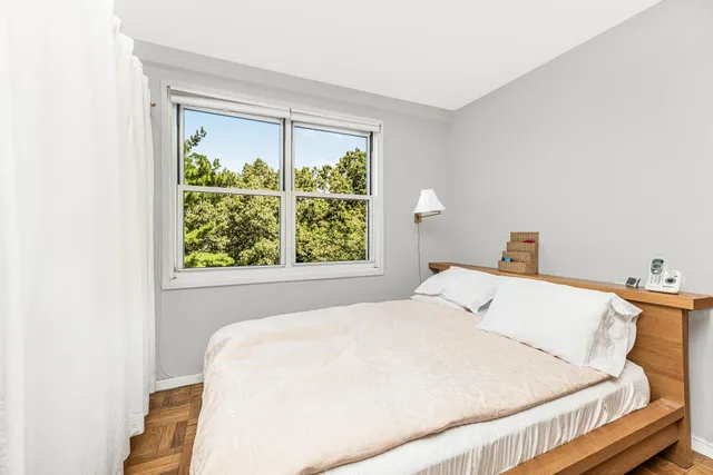 a living room with furniture a flat screen tv and a refrigerator
