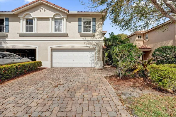 a front view of a house with a yard and a garage