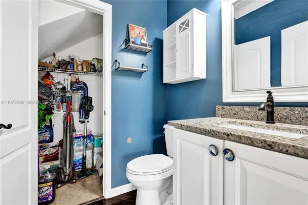 a bathroom with a granite countertop sink a toilet and a vanity
