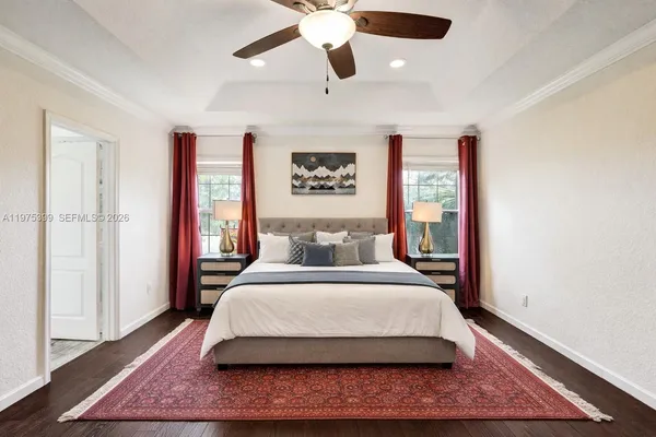 a bedroom with a large bed chandelier and a window