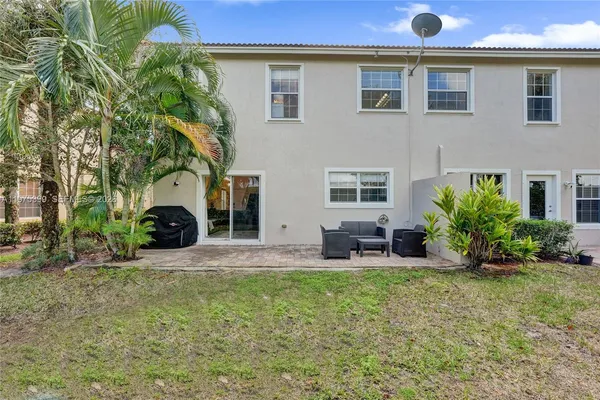 a view of a house with backyard and trees