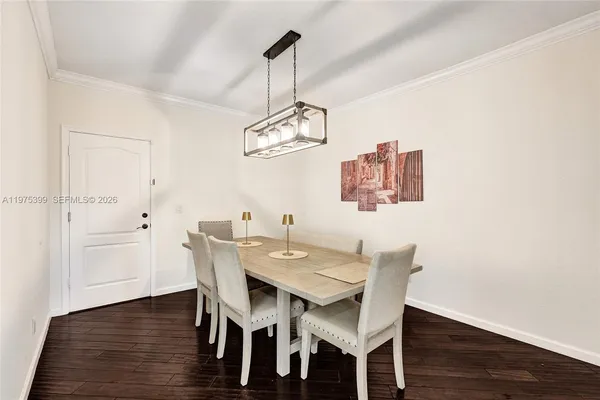 a view of a dining room with wooden floor a chandelier a wooden table and chairs