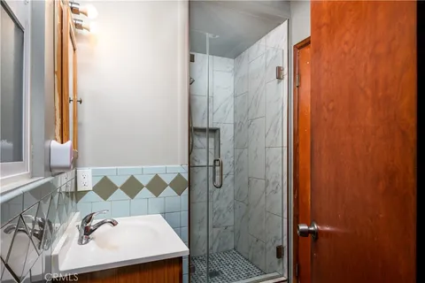 a bathroom with a sink a mirror and shower