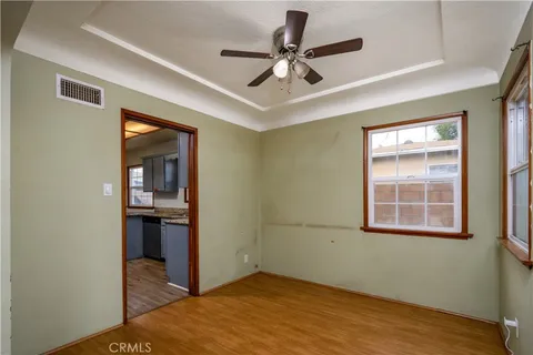 a view of empty room with wooden floor and ceiling fan