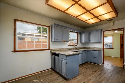 a kitchen with granite countertop cabinets stainless steel appliances a sink and wooden floor