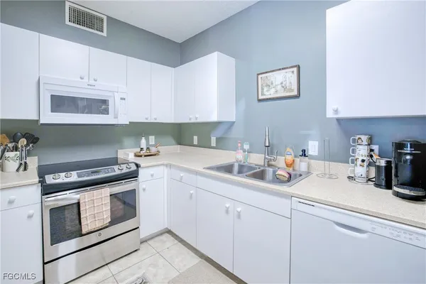 a kitchen with white cabinets and white appliances