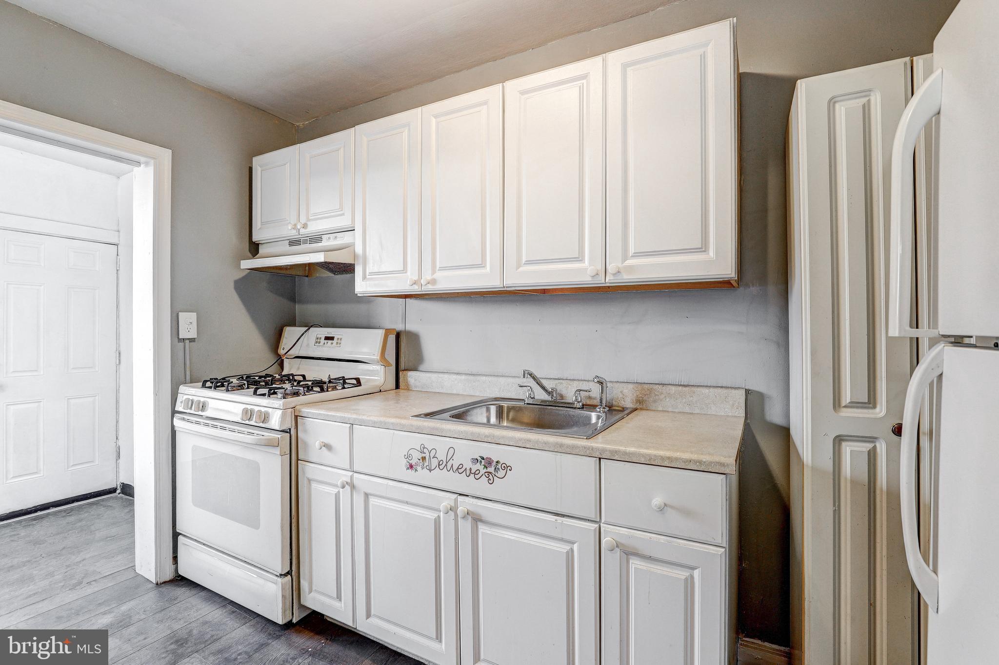 1913 Harman Avenue Baltimore, MD 21230 - Photo 14 of 41 a kitchen with stainless steel appliances granite countertop a sink stove and white cabinets