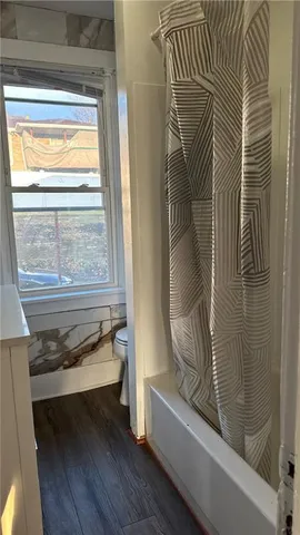 a bathroom with a bathtub and next to a window