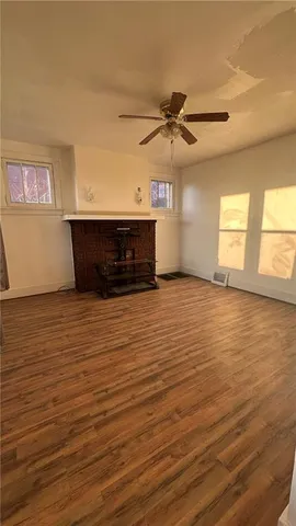 a view of a room with wooden floor and a ceiling fan