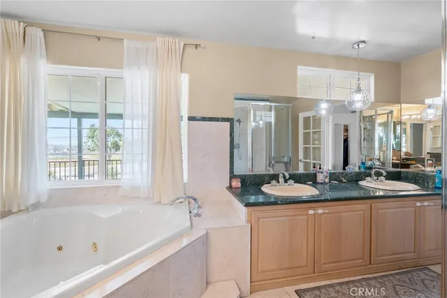 a bathroom with a granite countertop tub sink and mirror