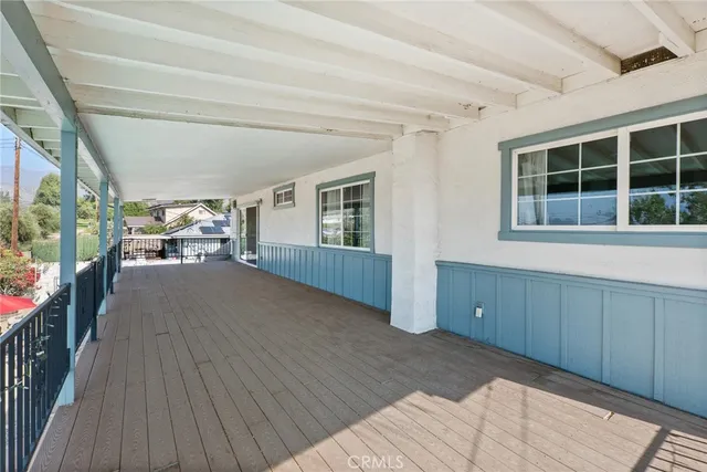 a view of empty room with wooden floor and windows