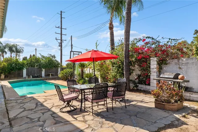 a patio with a table and chairs and potted plants