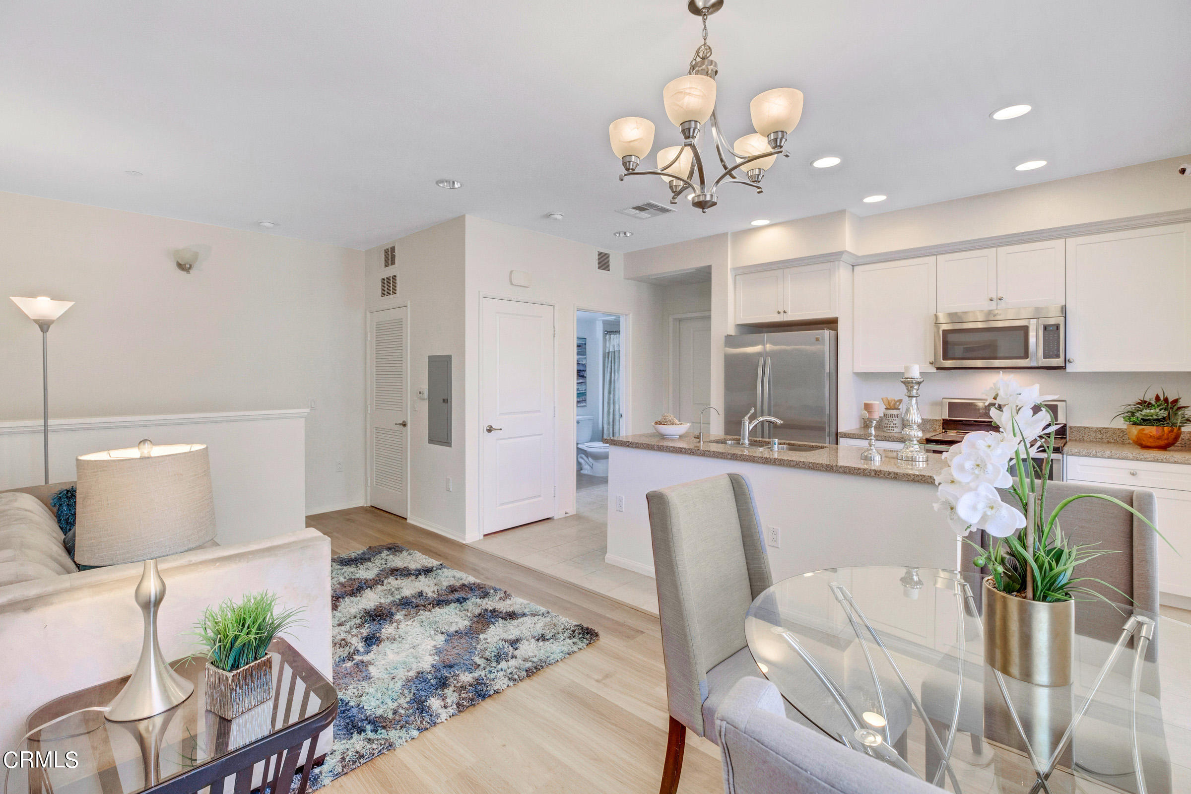 410 West Main Street, Unit 231 Alhambra, CA 91801 - Photo 14 of 45 a view of a dining room and kitchen with furniture wooden floor and a chandelier