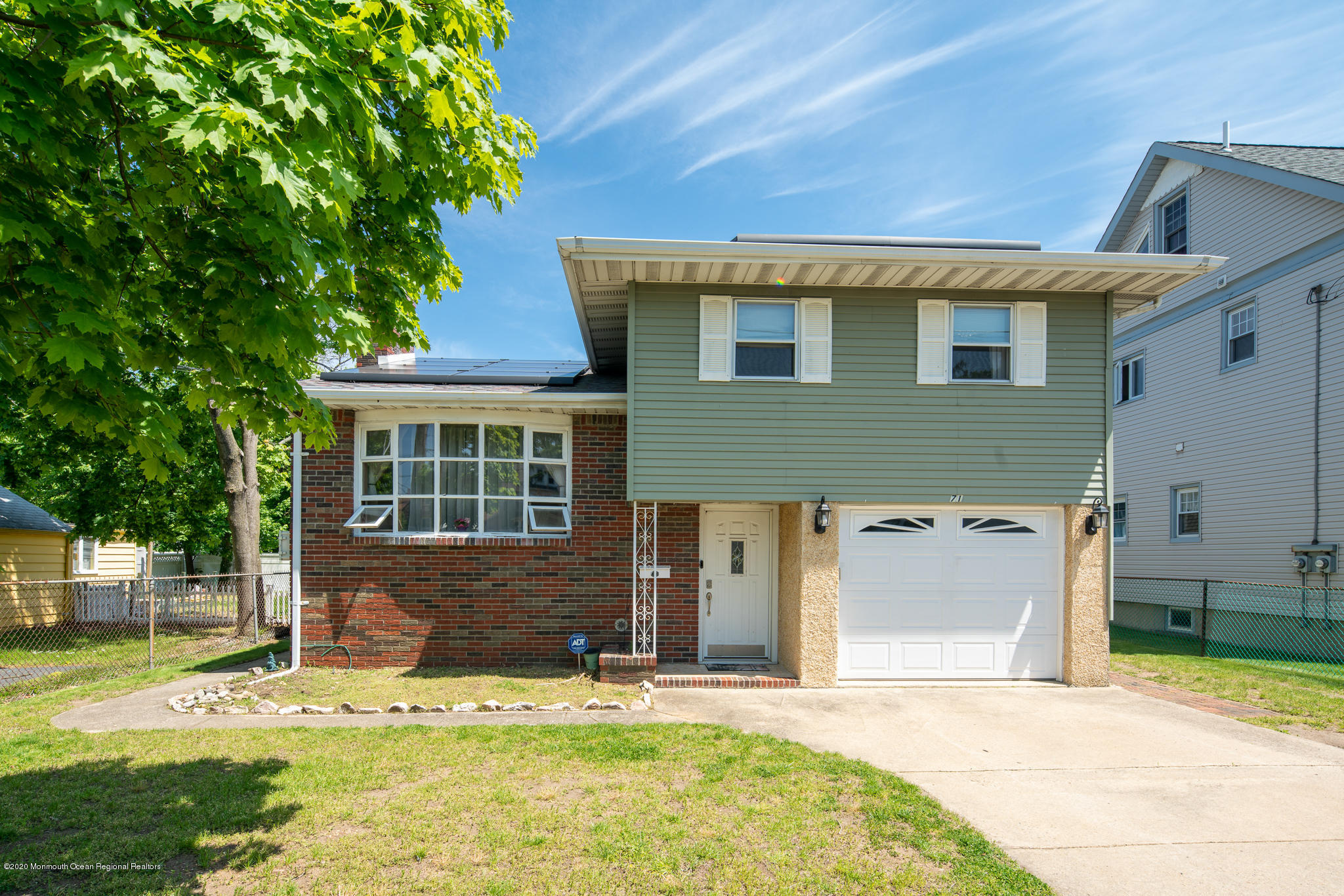 a front view of a house with a yard garage and sitting area