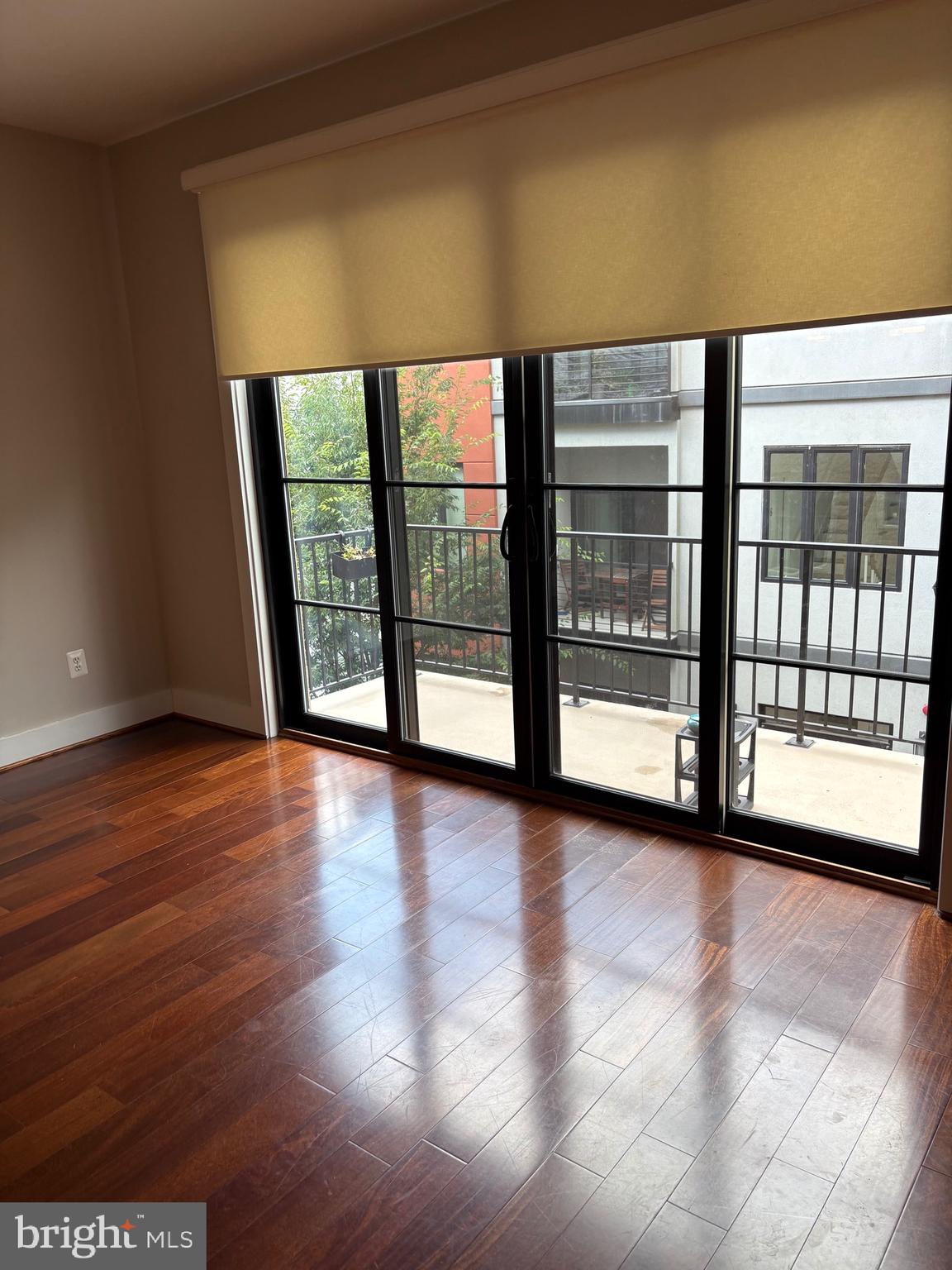 4004 Edmunds Street Northwest, Unit 7 Washington, DC 20007 - Photo 3 of 12 a view of an empty room with wooden floor and a window