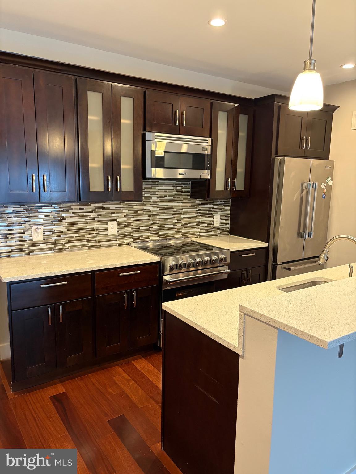 4004 Edmunds Street Northwest, Unit 7 Washington, DC 20007 - Photo 5 of 12 a kitchen with stainless steel appliances granite countertop wooden cabinets a oven a stove and a sink