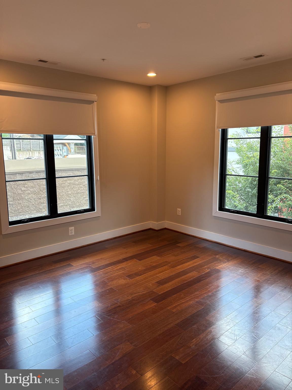 4004 Edmunds Street Northwest, Unit 7 Washington, DC 20007 - Photo 6 of 12 a view of an empty room with wooden floor and a window