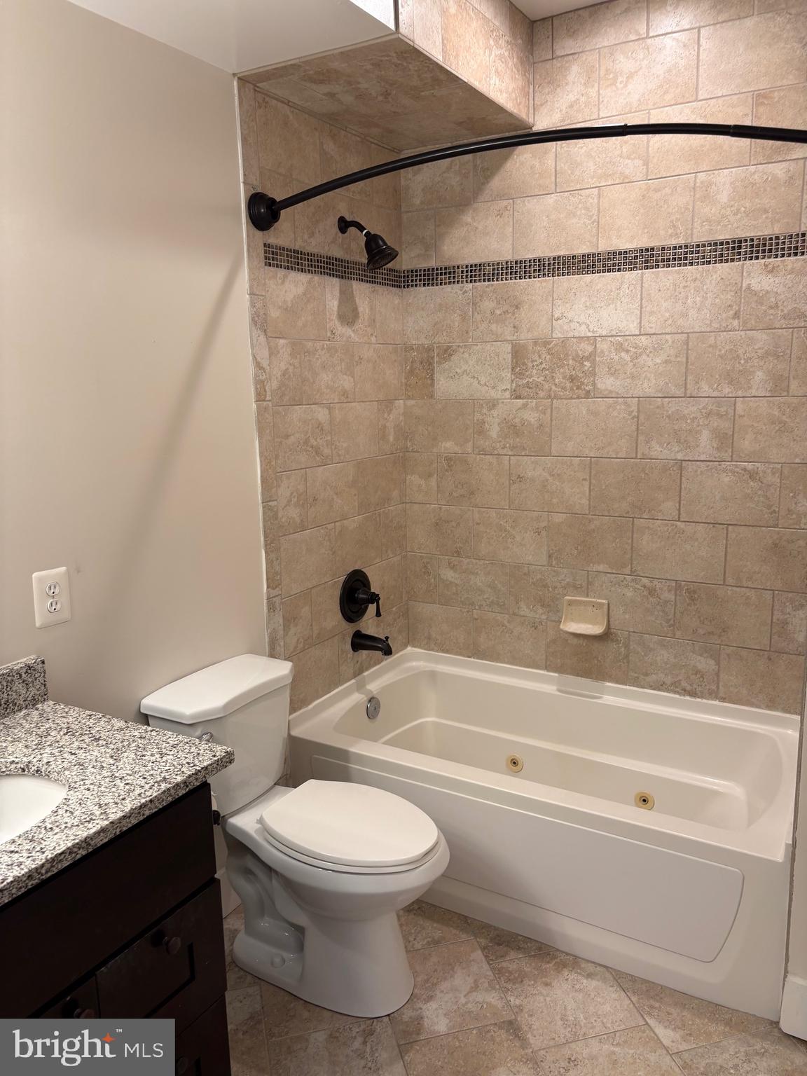 4004 Edmunds Street Northwest, Unit 7 Washington, DC 20007 - Photo 7 of 12 a bathroom with a granite countertop bathtub shower sink vanity and toilet