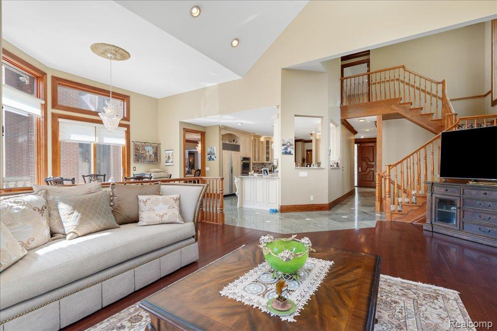 3543 Cedar Brook Drive Rochester, MI 48309 - Photo 25 of 99 Two-story vaulted ceilings, a grand wooden staircase, wood-finish flooring, recessed lighting, and a crystal chandelier