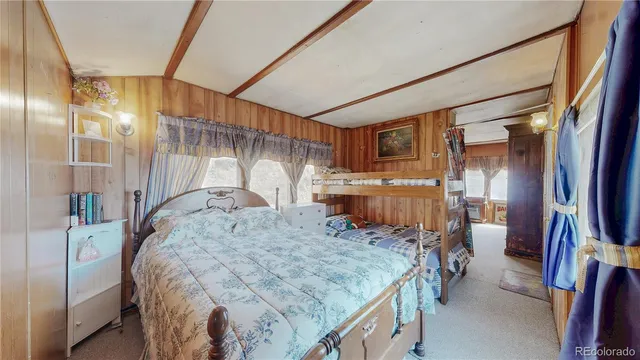 a bedroom with a bed and a flat tv screen on wall
