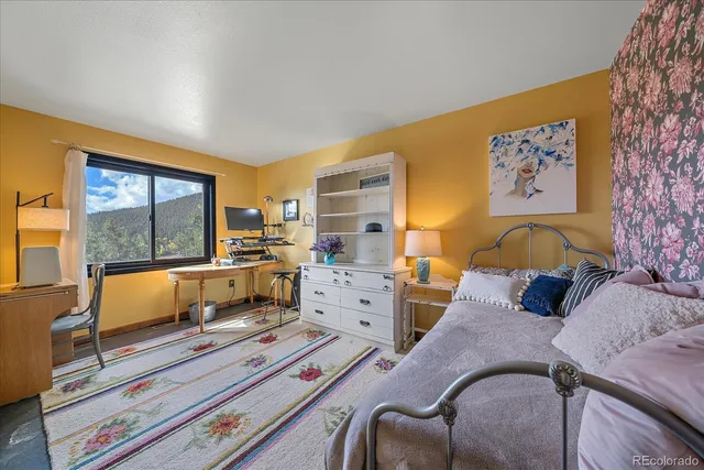 a bedroom with furniture and a large window