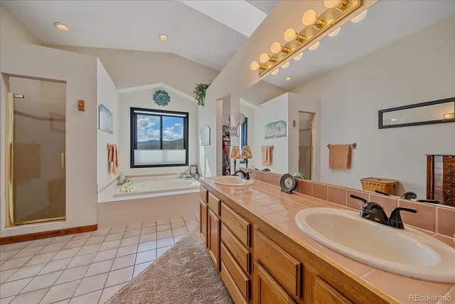 a bathroom with a double vanity sink a mirror and a bathtub