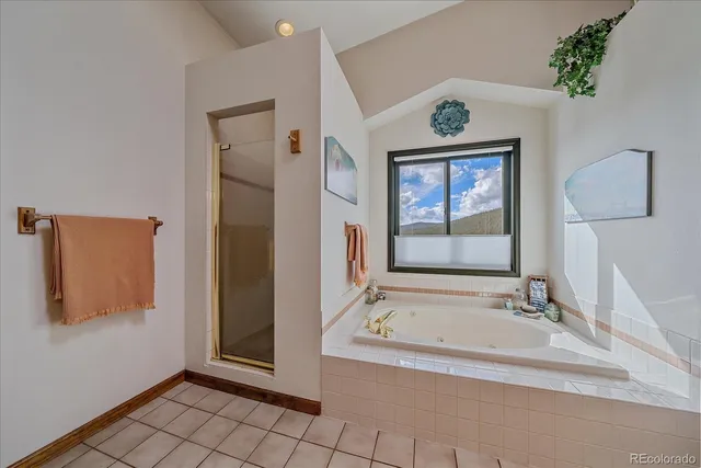 a bathroom with a tub a sink and mirror