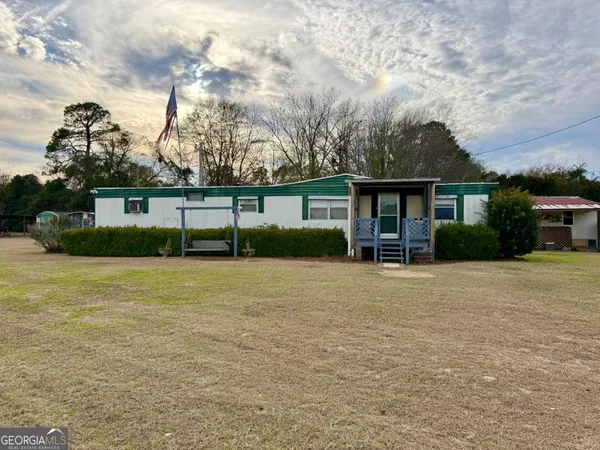 a view of a house with backyard and trees