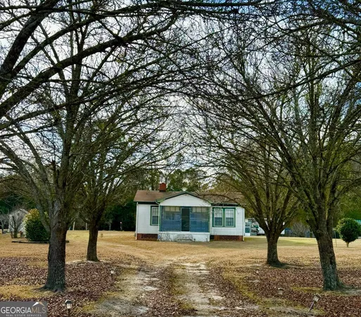 a front view of a house with a yard and large trees