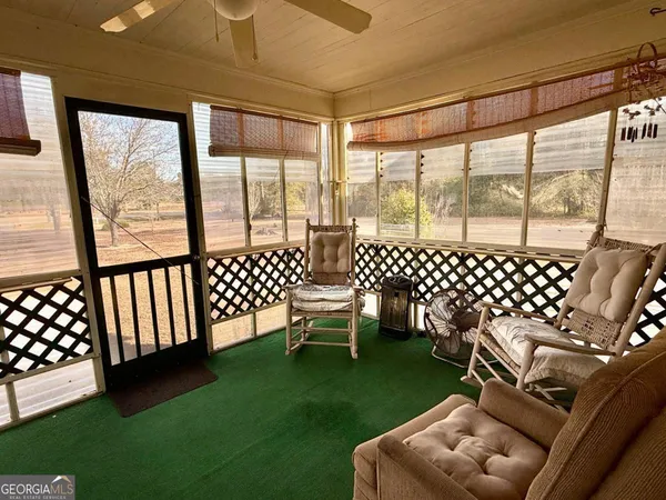 a living room with furniture floor to ceiling window and outdoor view
