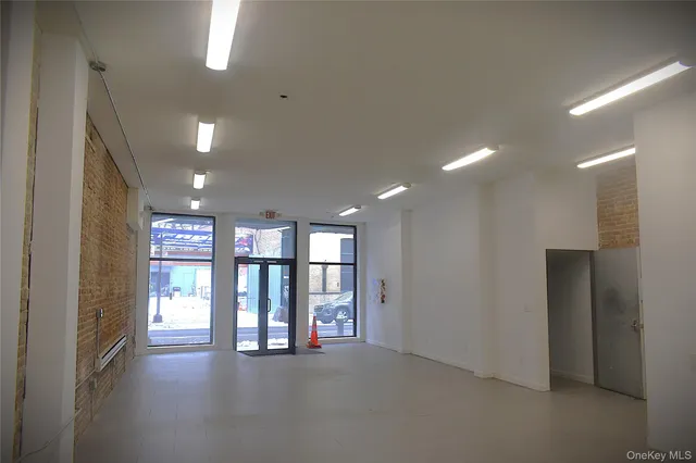 a view of water heater room with refrigerator and windows