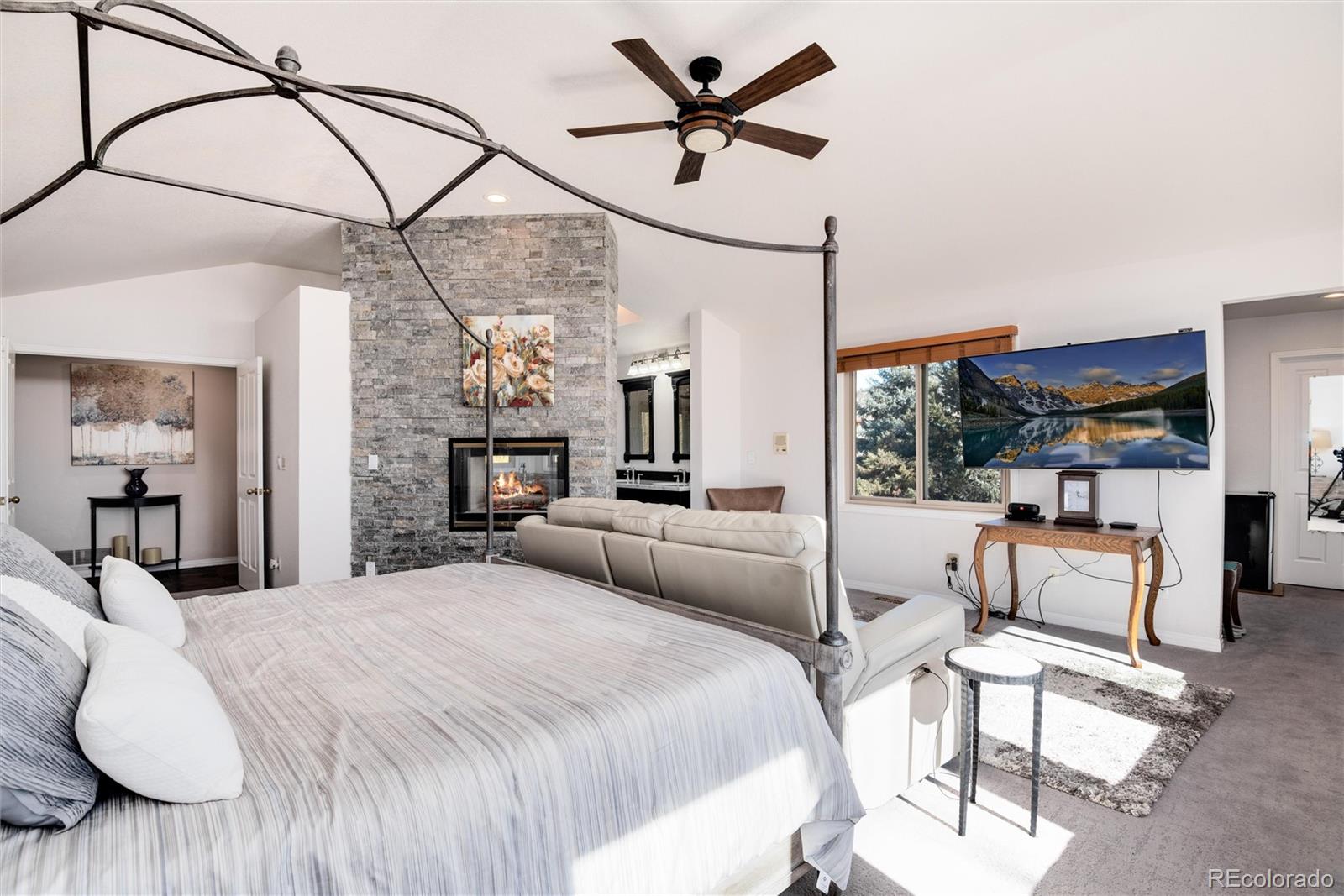 81 North Ranch Road Littleton, CO 80127 - Photo 17 of 38 a bedroom with a bed a couch and large window