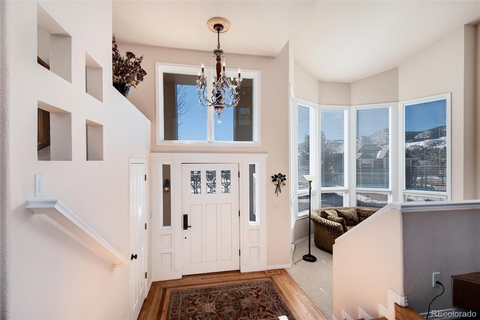 81 North Ranch Road Littleton, CO 80127 - Photo 4 of 38 a view of a hallway with windows and chandelier