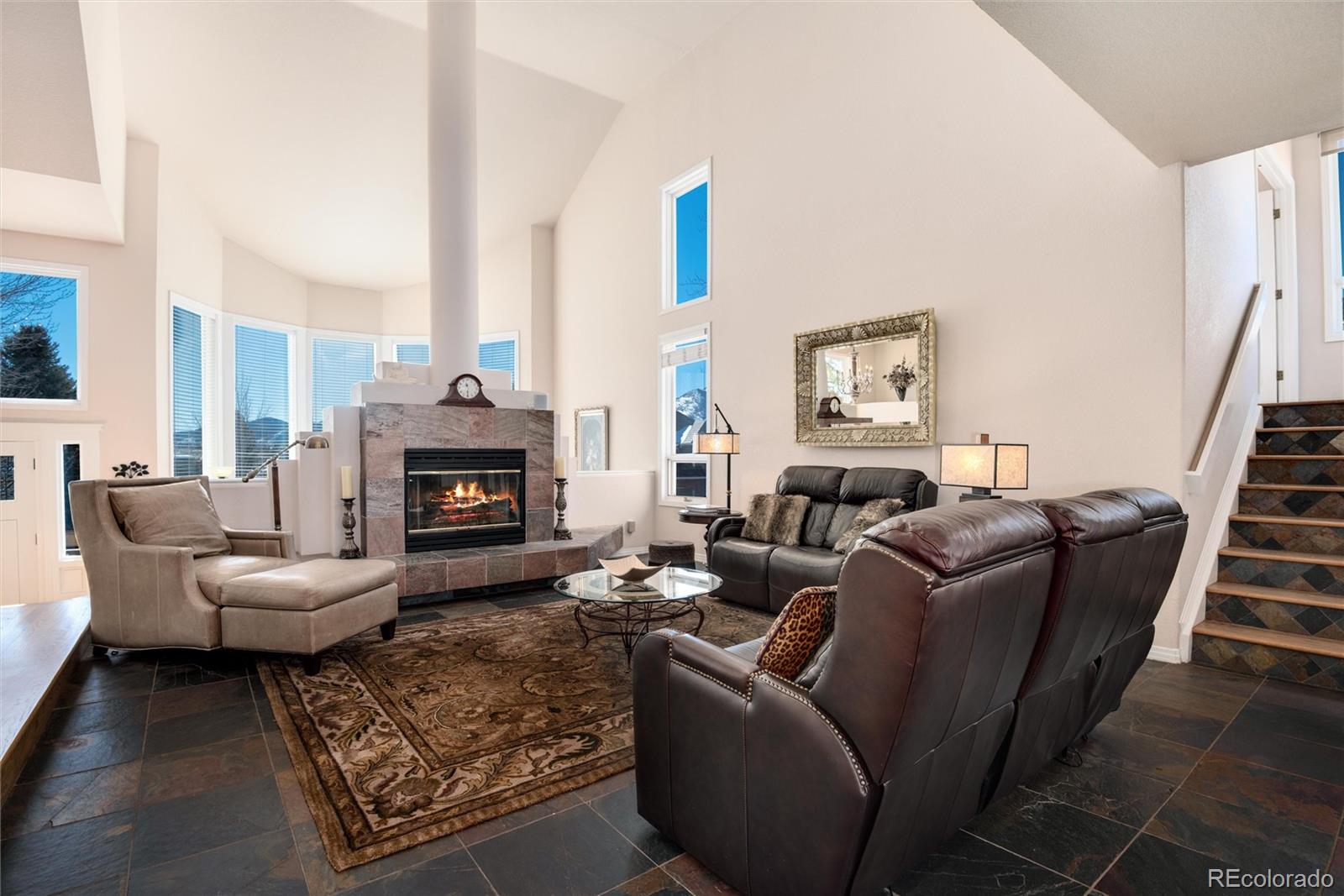 81 North Ranch Road Littleton, CO 80127 - Photo 6 of 38 a living room with furniture a fireplace and a large mirror next to a window